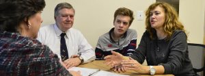 A family of three discusses trust options with Arc staff at a round table in an office